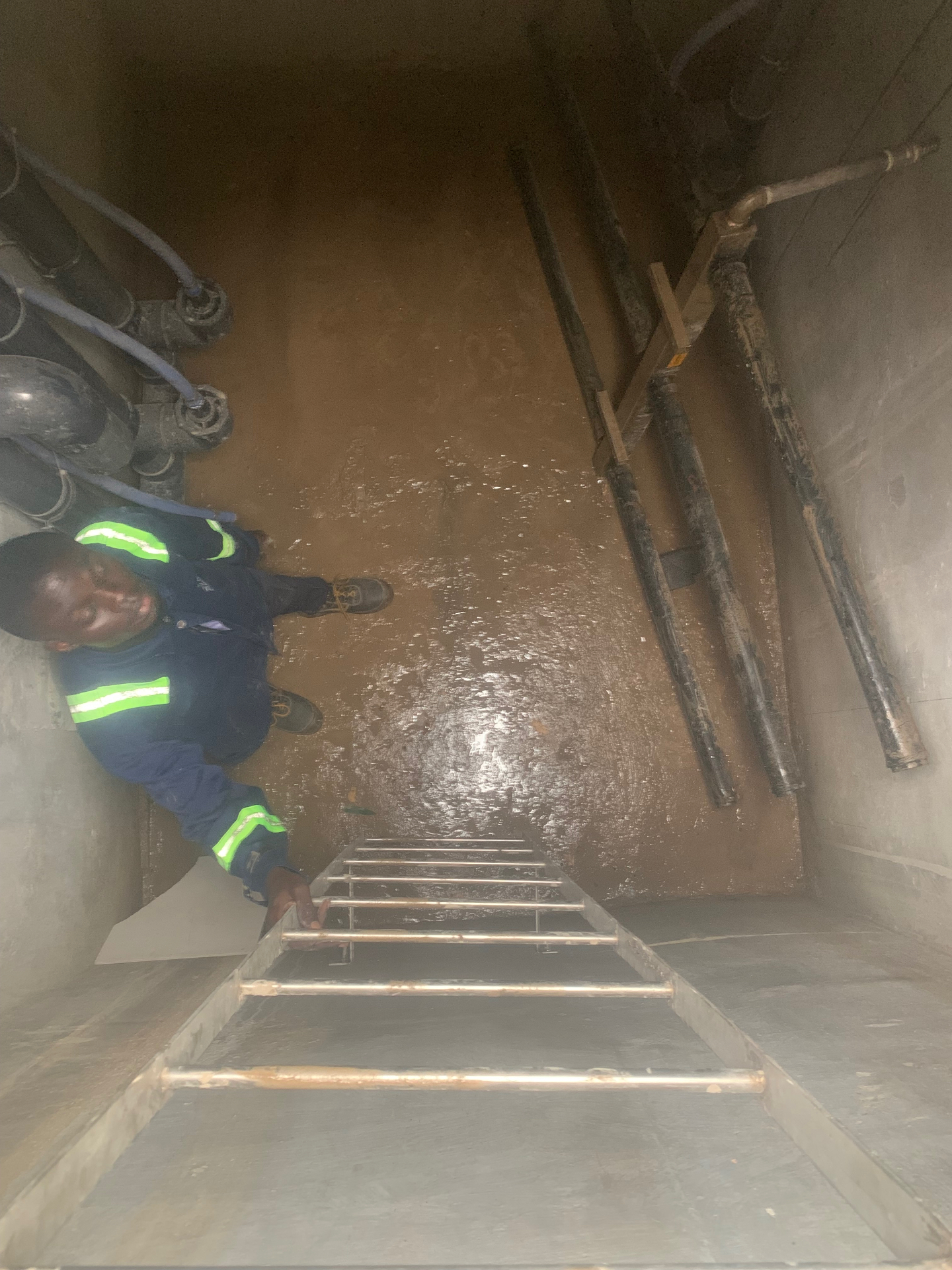 Technician inside underground water tank after waterproofing application